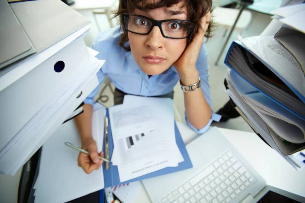 HR professional overwhelmed with paperwork and administrative tasks before using HRMS payroll management software.